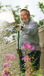 Man Watering Flowers in Garden